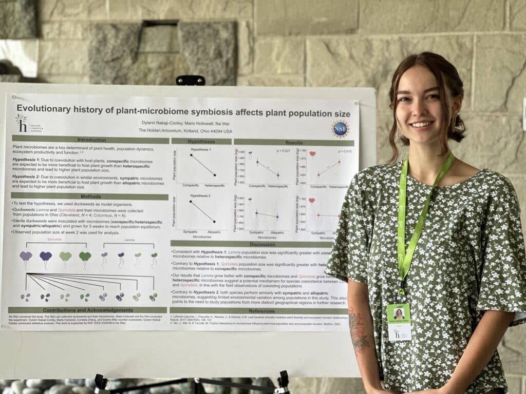 Dylann in front of poster of research on duckweeds